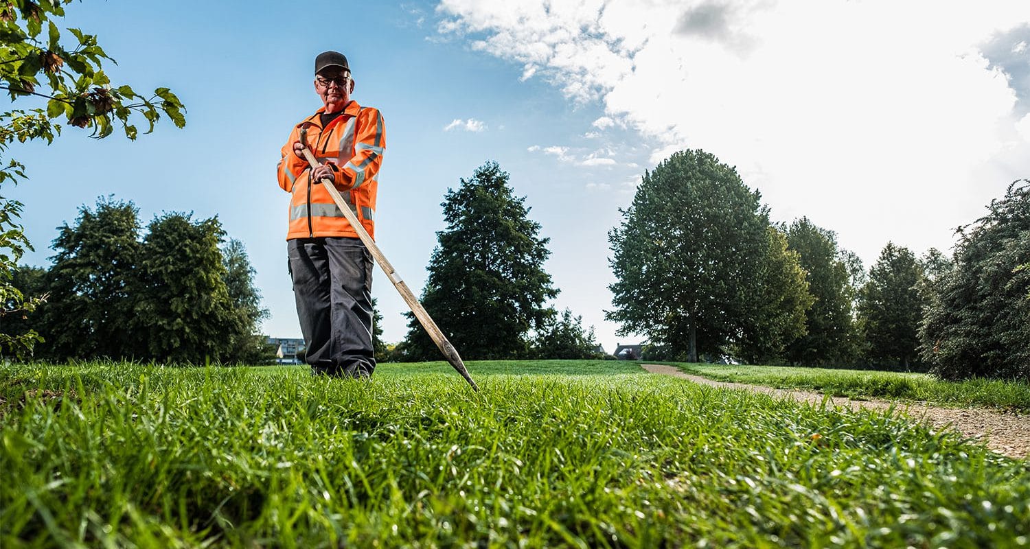 Medewerker groenvoorziening aan het werk in de hitte.