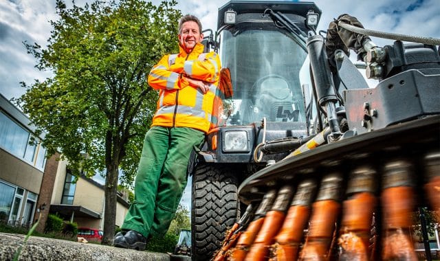 Medewerker van Globen samen met de veegwagen.