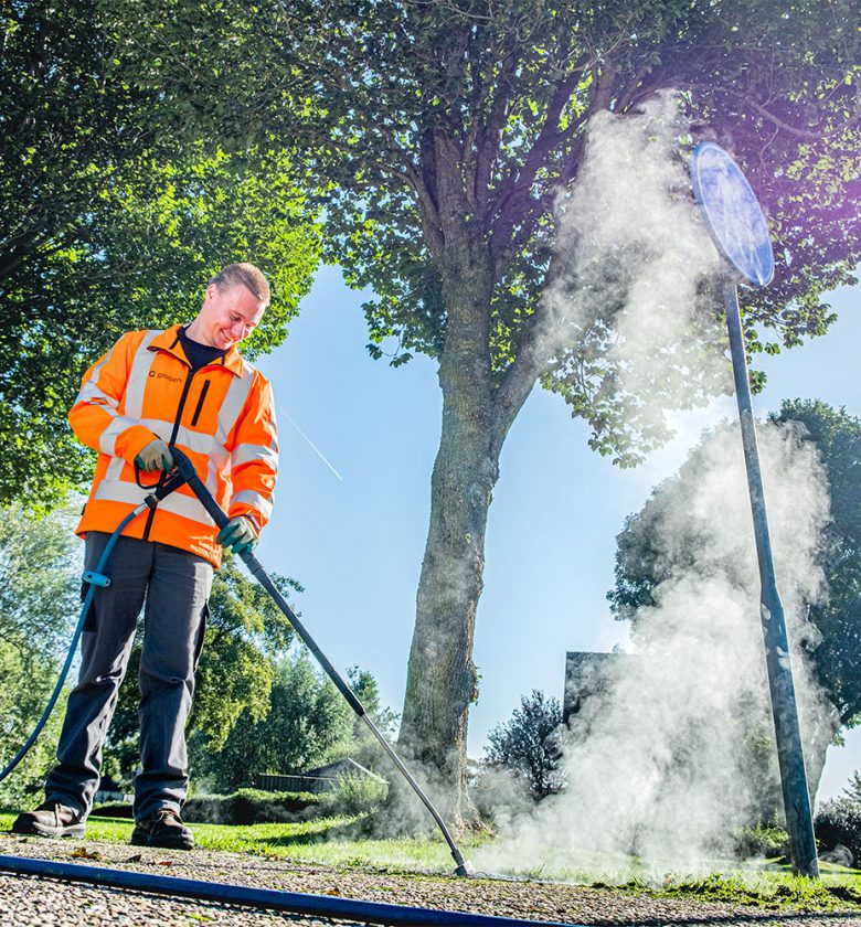 Medeweker groenvoorziening aan het werk met de onkruidverdelger.