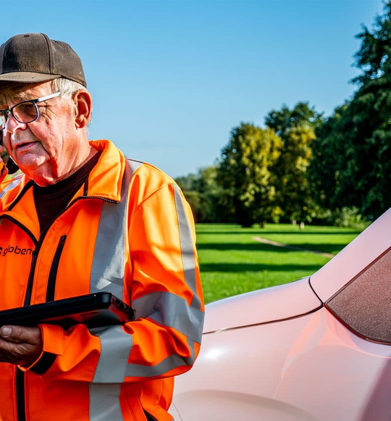 Medewerker Jan aan het telefoneren, terwijl hij werkt in de groenvoorziening