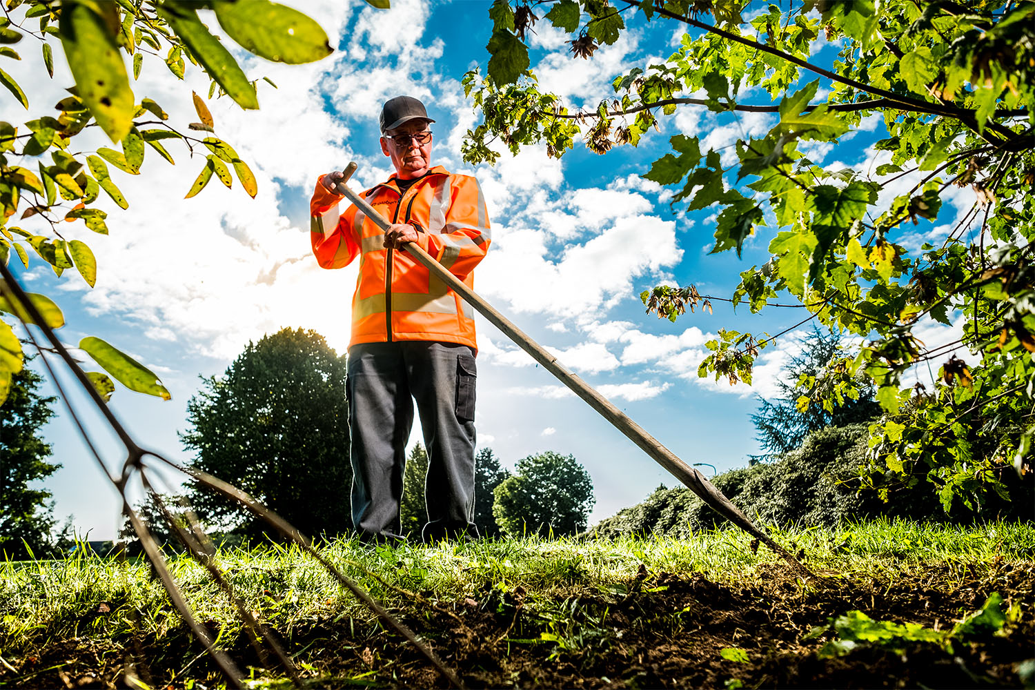 medewerker groenvoorziening aan het werk met een schoffel