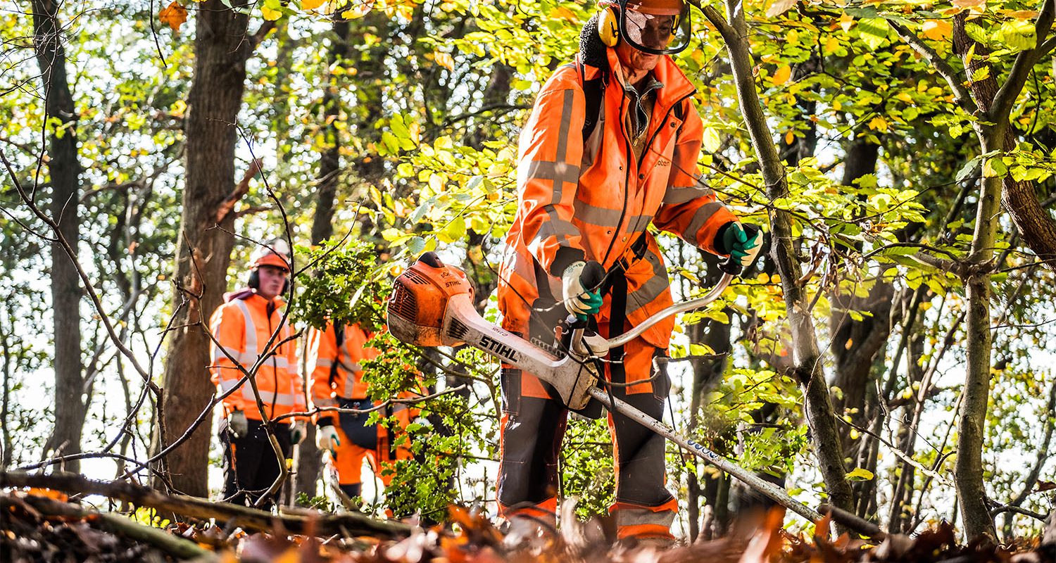 Een deelnemer van BBL opleiding medewerker buitenruimte aan het werk met de bosmaaier